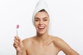 Smiling woman brushing her teeth with towel on her head. A great smile