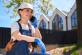 Smiling woman builder in uniform talking phone during break at work Royalty Free Stock Photo