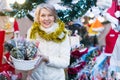 Smiling woman is buying Christmas flowers for ornamentals