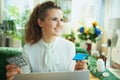 Smiling woman buying pharma in modern living room in sunny day