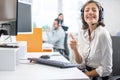 Smiling woman call center operator in headset showing thumbs up gesture. Royalty Free Stock Photo