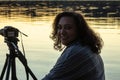 Smiling woman with camera looking out over water Royalty Free Stock Photo