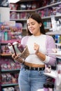 Smiling woman chooses a gift set for someone in cosmetics store