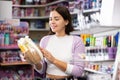 Smiling woman chooses a gift set for someone in cosmetics store