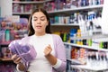 Smiling woman chooses a gift set for someone in cosmetics store