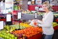 Smiling woman choosing different fruits at store Royalty Free Stock Photo