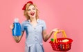 Smiling woman with cleaning products. Female cleaner holds basket with cleaning supplies. House chores. Royalty Free Stock Photo