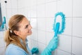 Smiling Woman Cleaning The Tiled Wall Of The Bathroom Royalty Free Stock Photo