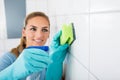 Smiling Woman Cleaning The White Tiled Wall Royalty Free Stock Photo