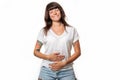A smiling woman closed her eyes and holds her stomach with hands. White background. Copy space. Concept of good digestion and