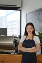 Smiling woman coffee shop owner standing at the counter and looking at camera. Royalty Free Stock Photo