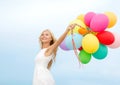 Smiling woman with colorful balloons outside Royalty Free Stock Photo