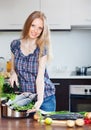 Smiling woman cooking lubina in skillet Royalty Free Stock Photo