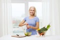 Smiling woman cooking vegetable salad at home