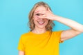 Smiling woman covering face with hand and peeping out fingers Royalty Free Stock Photo