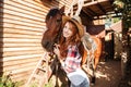 Smiling woman cowgirl in hat with her horse on farm Royalty Free Stock Photo