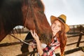 Smiling woman cowgirl standing with her horse on farm Royalty Free Stock Photo