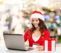 Smiling woman with credit card and laptop Royalty Free Stock Photo