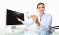 smiling woman with credit card in office at desk front of computer pointing at screen