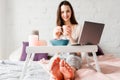 Smiling woman with cup of tea in bed Royalty Free Stock Photo