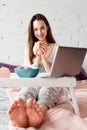 Smiling woman with cup of tea in bed Royalty Free Stock Photo