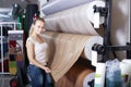 Smiling woman customer choosing linoleum flooring in hypermarket Royalty Free Stock Photo