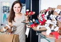 smiling woman customer selecting shoes in footgear center Royalty Free Stock Photo