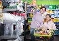 Smiling woman and daughter with shopping cart