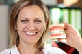 Smiling woman dentist holding model of jaws in her hands close-up. Royalty Free Stock Photo