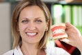 Smiling woman dentist shows jaws with artificial teeth close up. Royalty Free Stock Photo