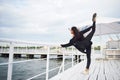 Smiling woman doing yoga exercise outdoors on the beach pier Royalty Free Stock Photo