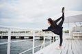 Smiling woman doing yoga exercise outdoors on the beach pier Royalty Free Stock Photo