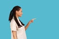 Smiling woman with dreadlocks pointing away with finger, showing blank space for your advertisement. Royalty Free Stock Photo