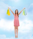 Smiling woman in dress with many shopping bags