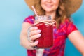 Smiling woman drink red juice. studio portrait with blue background and copy space Royalty Free Stock Photo