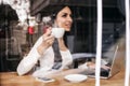 Smiling woman drinking coffee and surfing on internet. Cafe wind Royalty Free Stock Photo