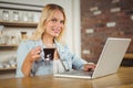 Smiling woman drinking coffee and typing on laptop Royalty Free Stock Photo