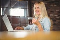 Smiling woman drinking coffee and typing on laptop Royalty Free Stock Photo