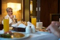 Smiling woman drinking tea and looking at blurred partial man having breakfast Royalty Free Stock Photo