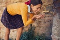 Smiling woman drinks from a drinking fountain Royalty Free Stock Photo