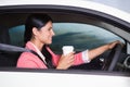 Smiling woman driving car while drinking coffee Royalty Free Stock Photo