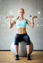 Smiling woman with dumbbells and exercise ball Royalty Free Stock Photo