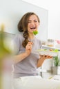 Smiling woman eating fresh salad in kitchen Royalty Free Stock Photo