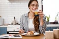 Smiling woman eating pancakes and drinking juice while having breakfast Royalty Free Stock Photo