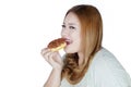 Smiling woman eats donut in studio Royalty Free Stock Photo