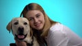 Smiling woman embracing cute labrador dog, looking at camera, pet is best friend