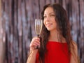 smiling woman in evening dress with glass of sparkling wine over christmas tree lights background Royalty Free Stock Photo