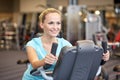 Smiling woman exercising on exercise bike in gym Royalty Free Stock Photo