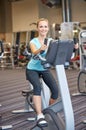 Smiling woman exercising on exercise bike in gym Royalty Free Stock Photo