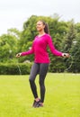 Smiling woman exercising with jump-rope outdoors Royalty Free Stock Photo